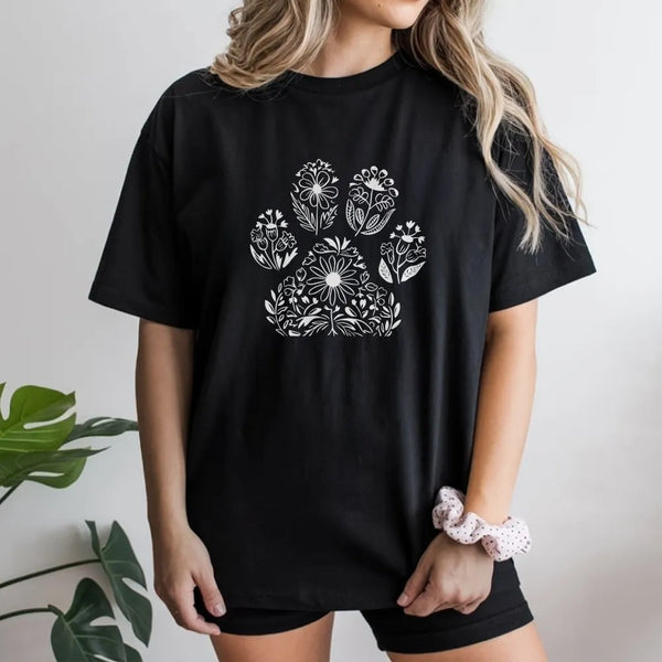 Model wearing a black t-shirt with a botanical floral dog paw print