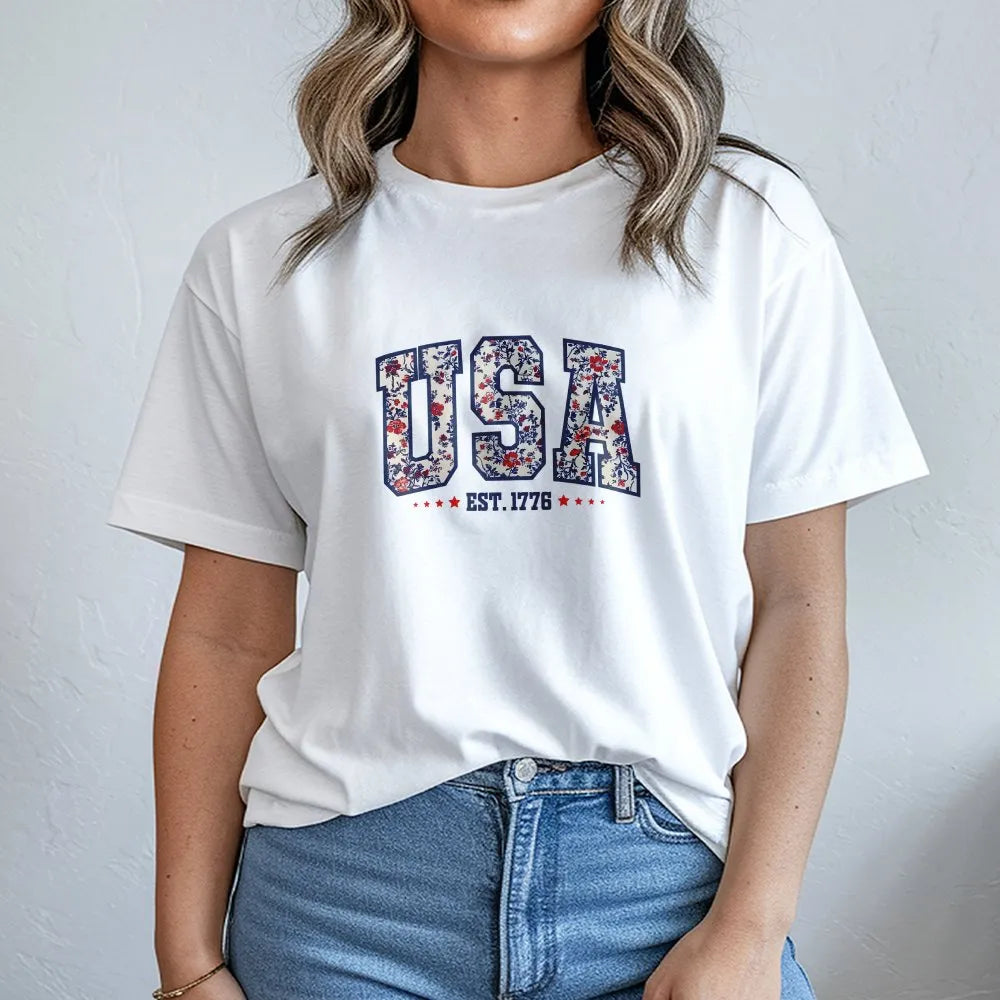 Model wearing a white t-shirt with a floral USA Est. 1776 print